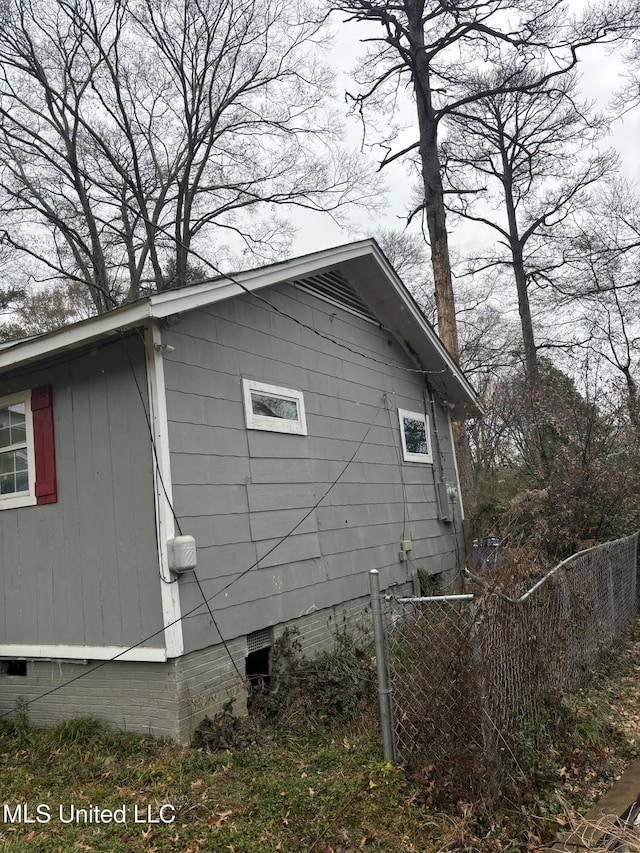 view of property exterior with crawl space and fence