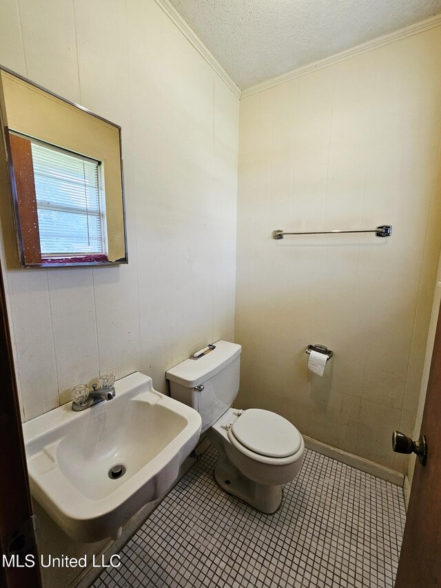 800 S Main St, Picayune, MS 39466 - bathroom featuring toilet, ornamental molding, a sink, a textured ceiling, and tile patterned flooring