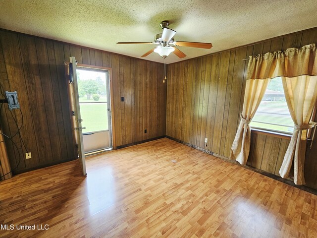 800 S Main St, Picayune, MS 39466 - unfurnished room with light wood finished floors, ceiling fan, wood walls, and a textured ceiling