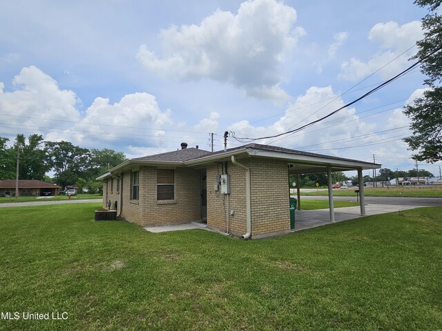 800 S Main St, Picayune, MS 39466 - view of side of home featuring a lawn, brick siding, a carport, and central AC unit