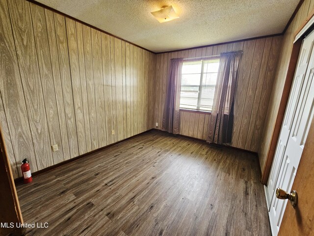 800 S Main St, Picayune, MS 39466 - empty room with wood finished floors, wood walls, and a textured ceiling