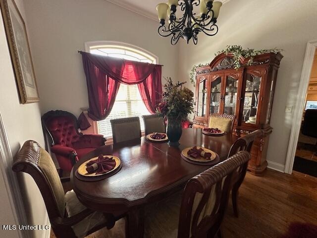 dining room with crown molding, an inviting chandelier, and hardwood / wood-style floors