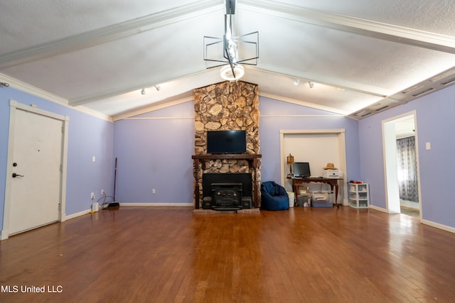 living room featuring hardwood / wood-style floors, lofted ceiling with beams, a stone fireplace, and ornamental molding