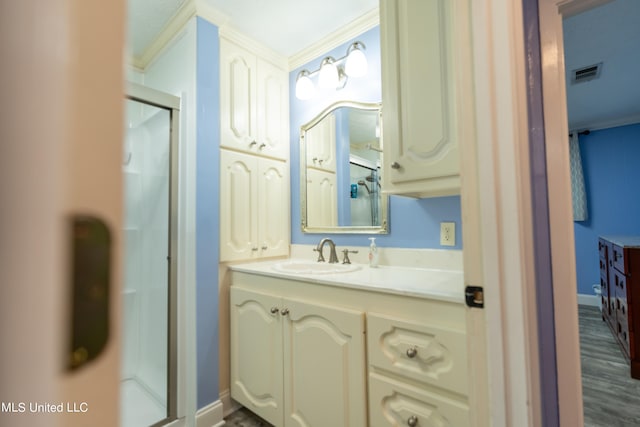 bathroom with wood-type flooring, vanity, an enclosed shower, and crown molding