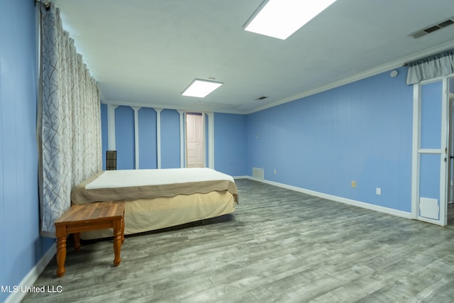 bedroom featuring hardwood / wood-style floors and crown molding