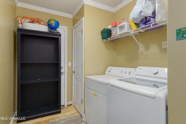 laundry room with ornamental molding, light wood-style floors, independent washer and dryer, and a textured ceiling