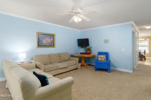 carpeted living area with a ceiling fan, baseboards, and crown molding