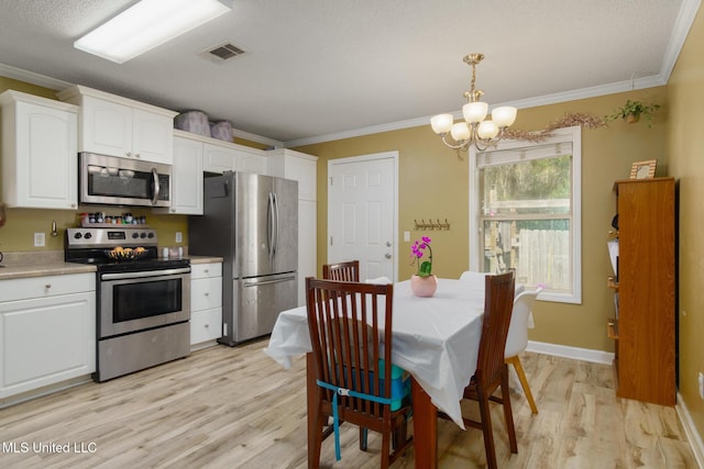 kitchen featuring stainless steel appliances, white cabinets, ornamental molding, and visible vents