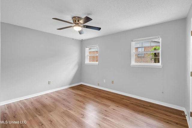 unfurnished room with ceiling fan, light wood-style floors, and baseboards