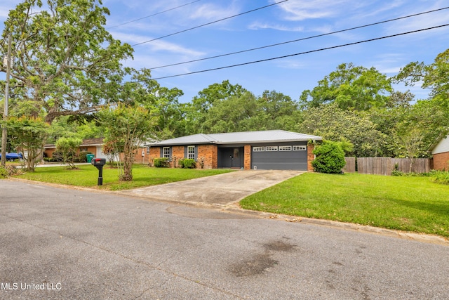 single story home featuring a front yard, a garage, driveway, brick siding, and fence
