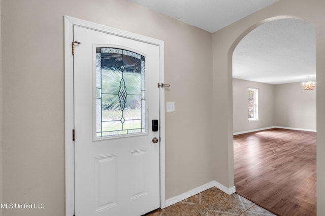 foyer entrance with baseboards and arched walkways