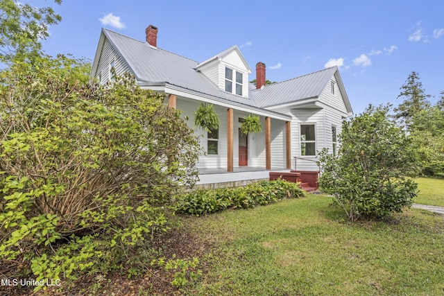 21021 Old River Rd, Vancleave, MS 39565 - view of front of house featuring a chimney, a porch, a front lawn, and metal roof