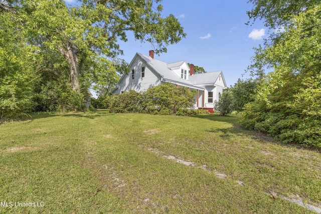 21021 Old River Rd, Vancleave, MS 39565 - view of side of home featuring a lawn, a chimney, and metal roof