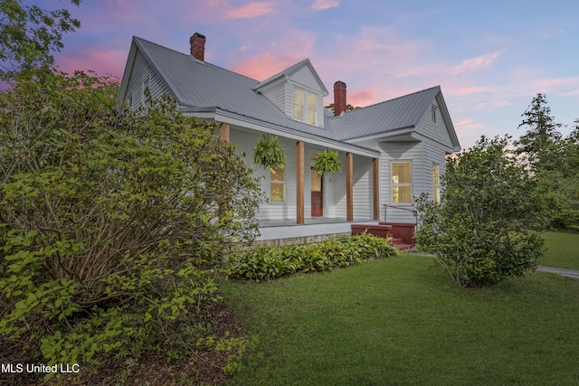 21021 Old River Rd, Vancleave, MS 39565 - view of front of home featuring a chimney, covered porch, a lawn, and metal roof