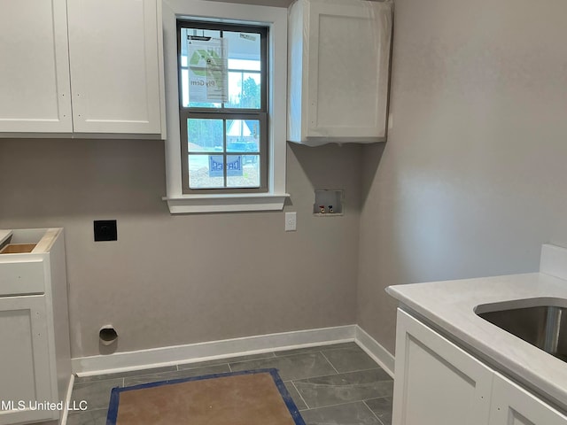 laundry area with hookup for a washing machine, hookup for an electric dryer, a sink, baseboards, and cabinet space