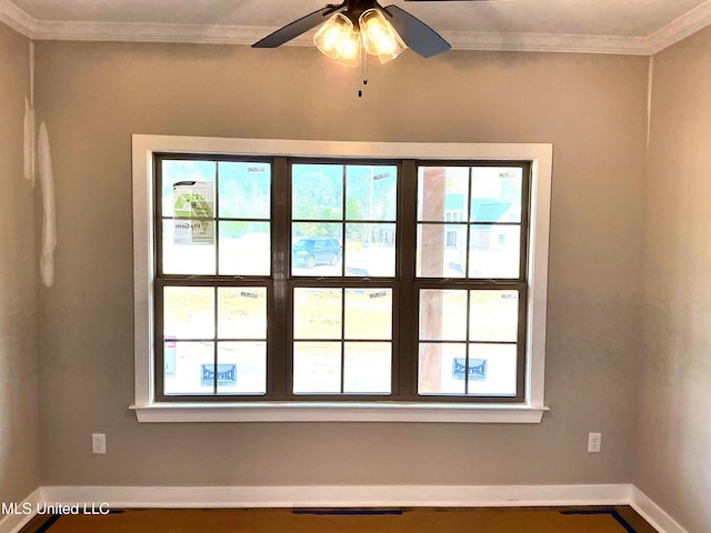 empty room featuring baseboards, visible vents, ornamental molding, and ceiling fan