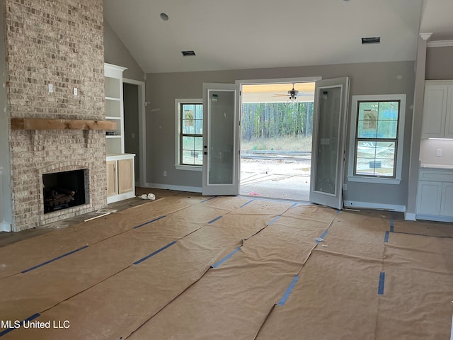 unfurnished living room featuring built in features, visible vents, a large fireplace, high vaulted ceiling, and baseboards