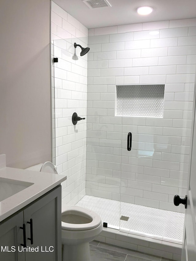 full bathroom with toilet, a shower stall, visible vents, and vanity