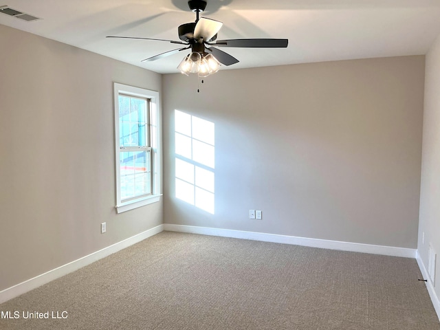 unfurnished room featuring a ceiling fan, carpet, visible vents, and baseboards