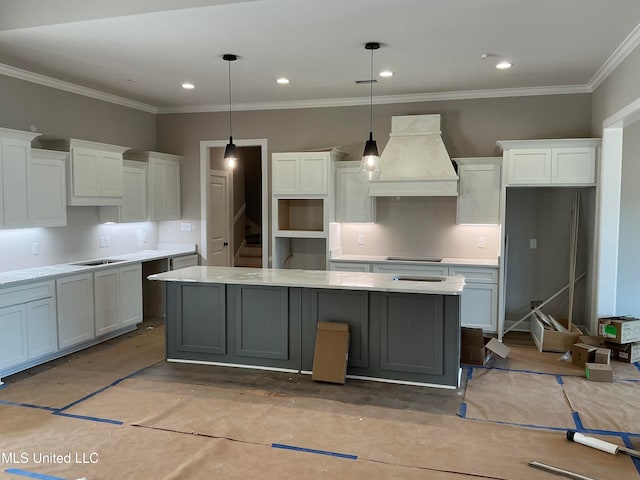 kitchen featuring black electric cooktop, premium range hood, white cabinets, hanging light fixtures, and a center island