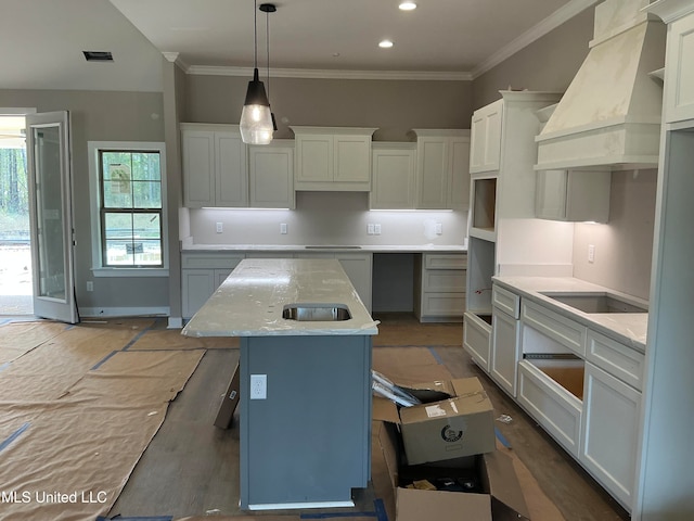 kitchen featuring decorative light fixtures, custom exhaust hood, white cabinetry, a kitchen island, and light stone countertops