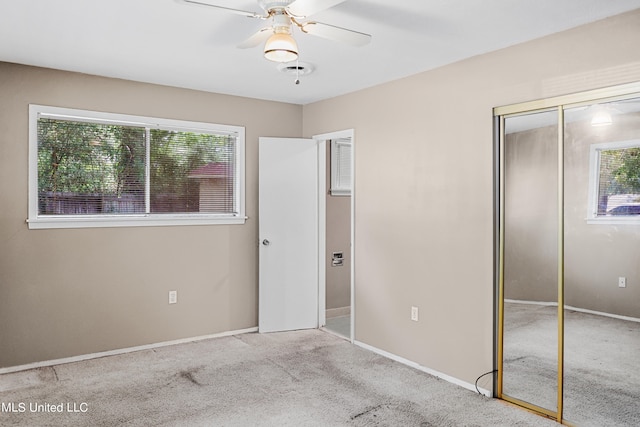 unfurnished bedroom with a closet, light colored carpet, and ceiling fan