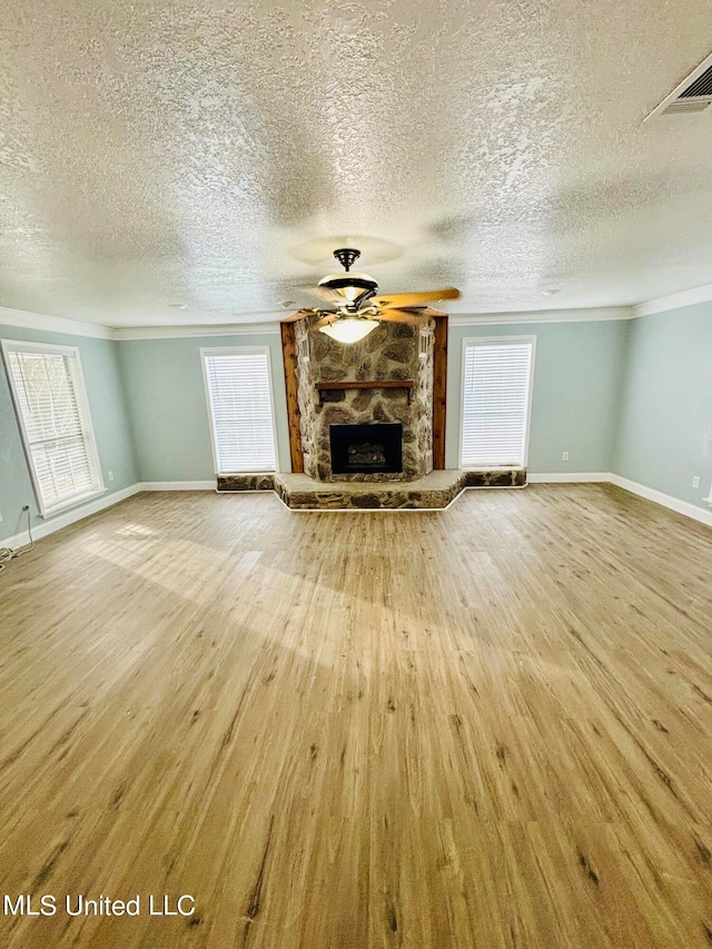 unfurnished living room with a textured ceiling, a healthy amount of sunlight, and hardwood / wood-style floors