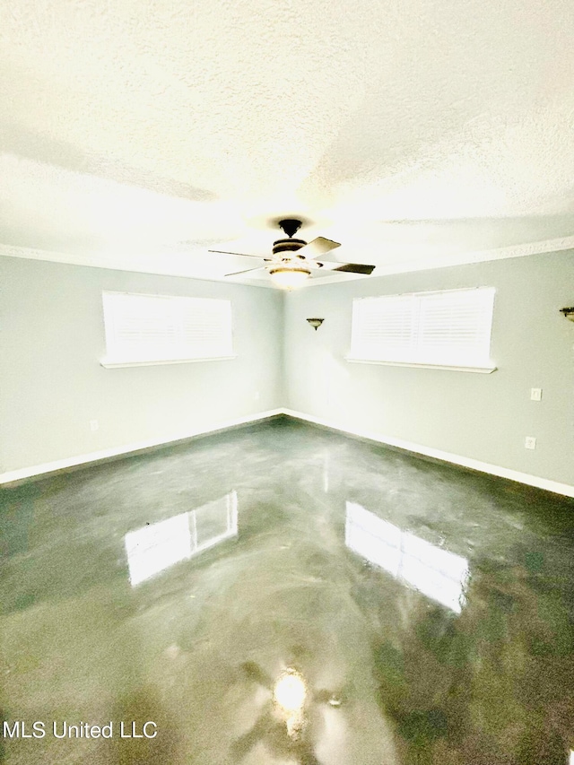 unfurnished room with ceiling fan and a textured ceiling