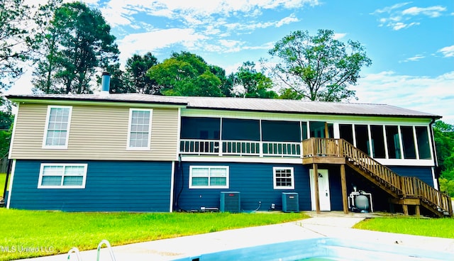 rear view of property with cooling unit and a sunroom