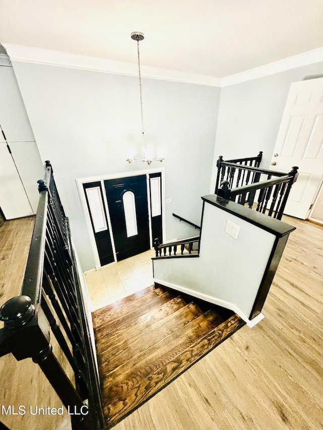 foyer featuring ornamental molding, a chandelier, and light wood-type flooring