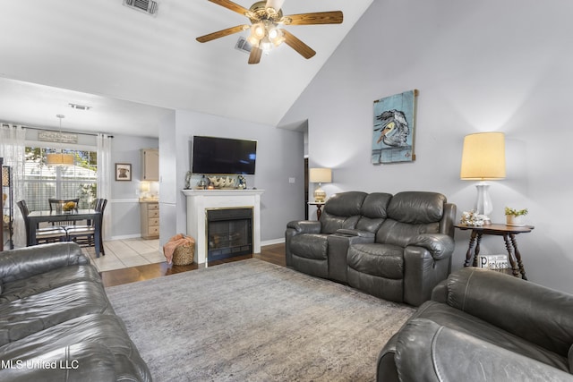 13625 Mount Pleasant Rd, Vancleave, MS 39565 - living room featuring a ceiling fan, high vaulted ceiling, a fireplace with flush hearth, and light wood finished floors