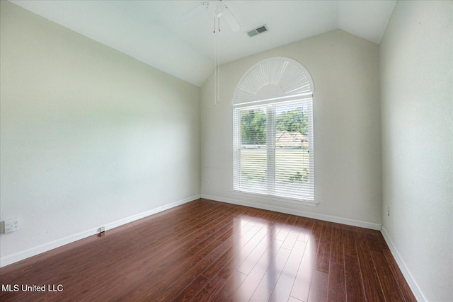 unfurnished room with dark wood finished floors, a ceiling fan, baseboards, vaulted ceiling, and visible vents