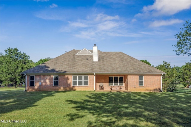 back of house with a lawn, brick siding, and a chimney