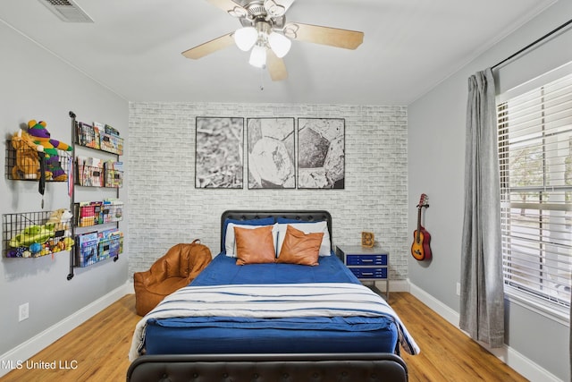 bedroom with multiple windows, wood finished floors, and visible vents