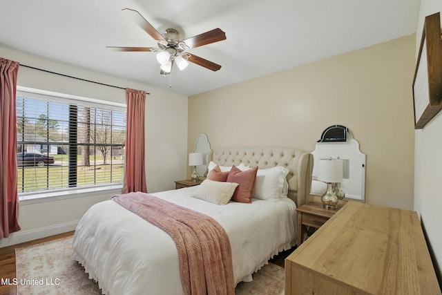 bedroom featuring a ceiling fan, light wood-style floors, and baseboards