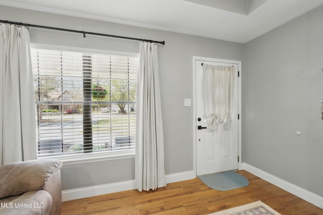 entryway featuring baseboards and wood finished floors