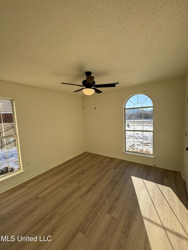 unfurnished room with hardwood / wood-style floors, ceiling fan, and a textured ceiling