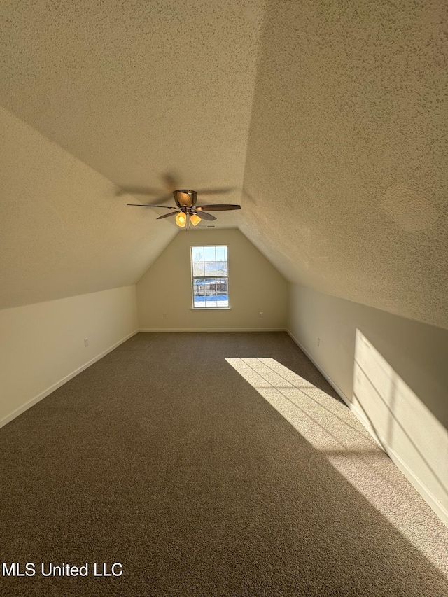 additional living space with carpet flooring, ceiling fan, a textured ceiling, and vaulted ceiling