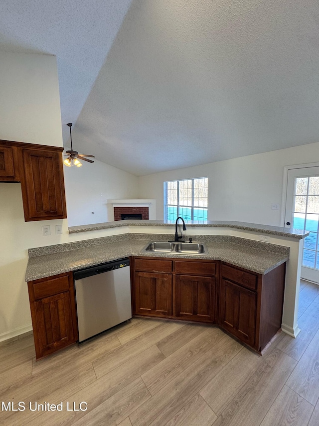 kitchen featuring dishwasher, lofted ceiling, sink, light hardwood / wood-style flooring, and ceiling fan