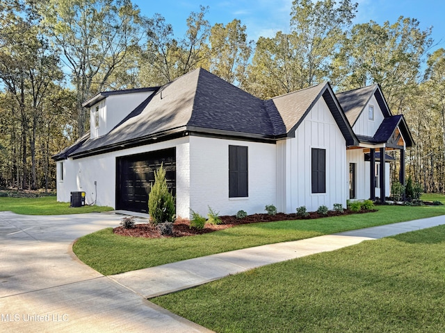 view of side of home featuring central air condition unit, a lawn, and a garage