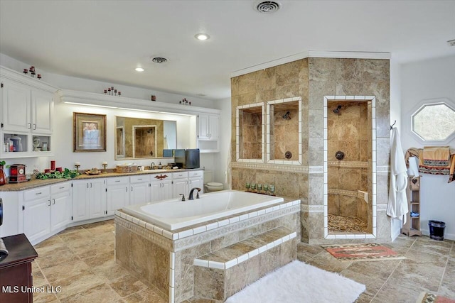 full bathroom with vanity, shower with separate bathtub, and toilet