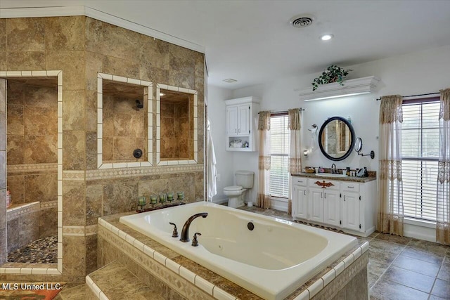 bathroom with toilet, vanity, and tiled bath