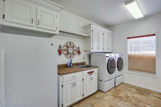 clothes washing area featuring washer and dryer, sink, and cabinets