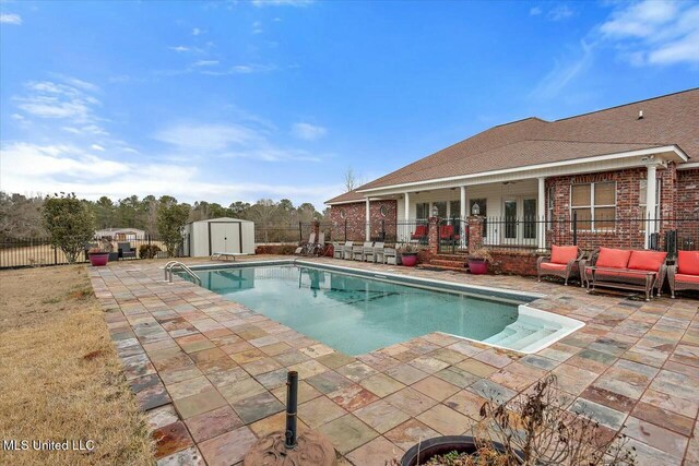 view of pool featuring a patio and a storage unit