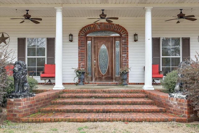 view of exterior entry featuring ceiling fan and covered porch