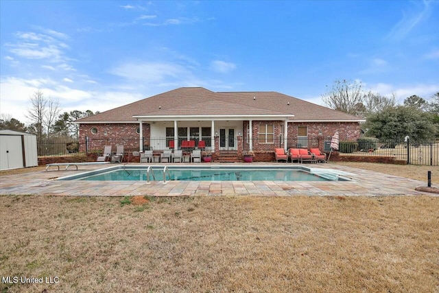 view of pool with a yard, a patio area, and a shed