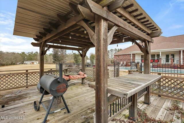 deck featuring grilling area and a community pool