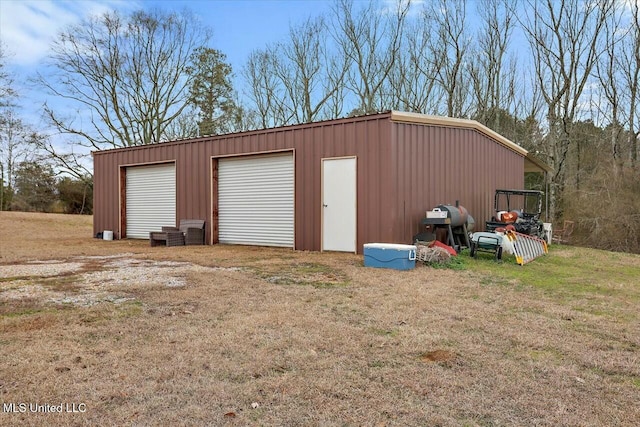 view of outdoor structure featuring a garage and a lawn