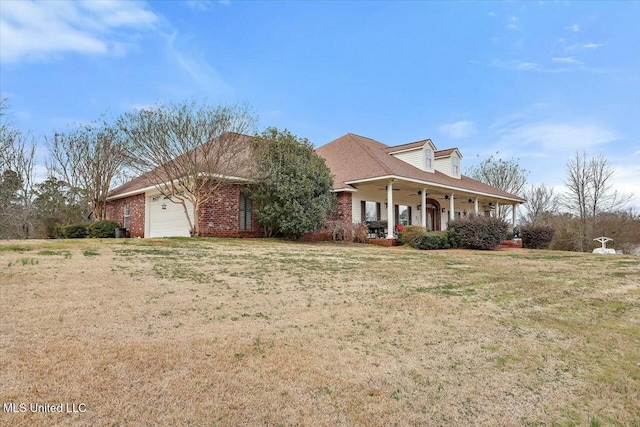 view of front of house with a garage, covered porch, and a front yard