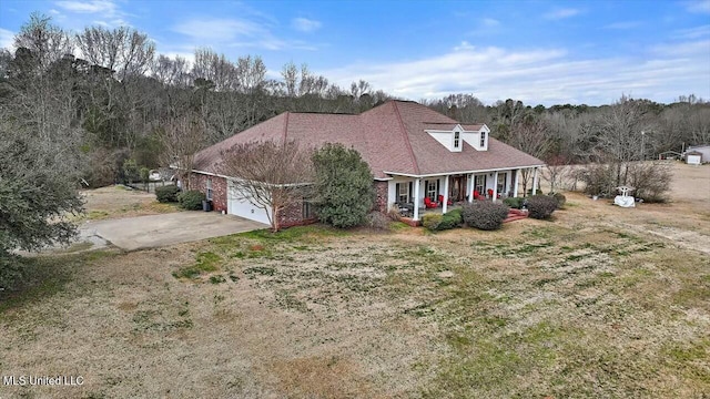 cape cod-style house featuring a porch, a garage, and a front lawn